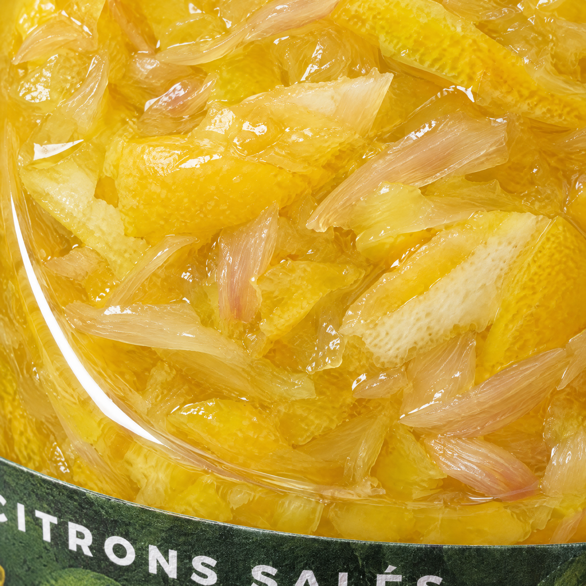 Gros plan sur la matière des citrons confits salés au combava à travers le verre
